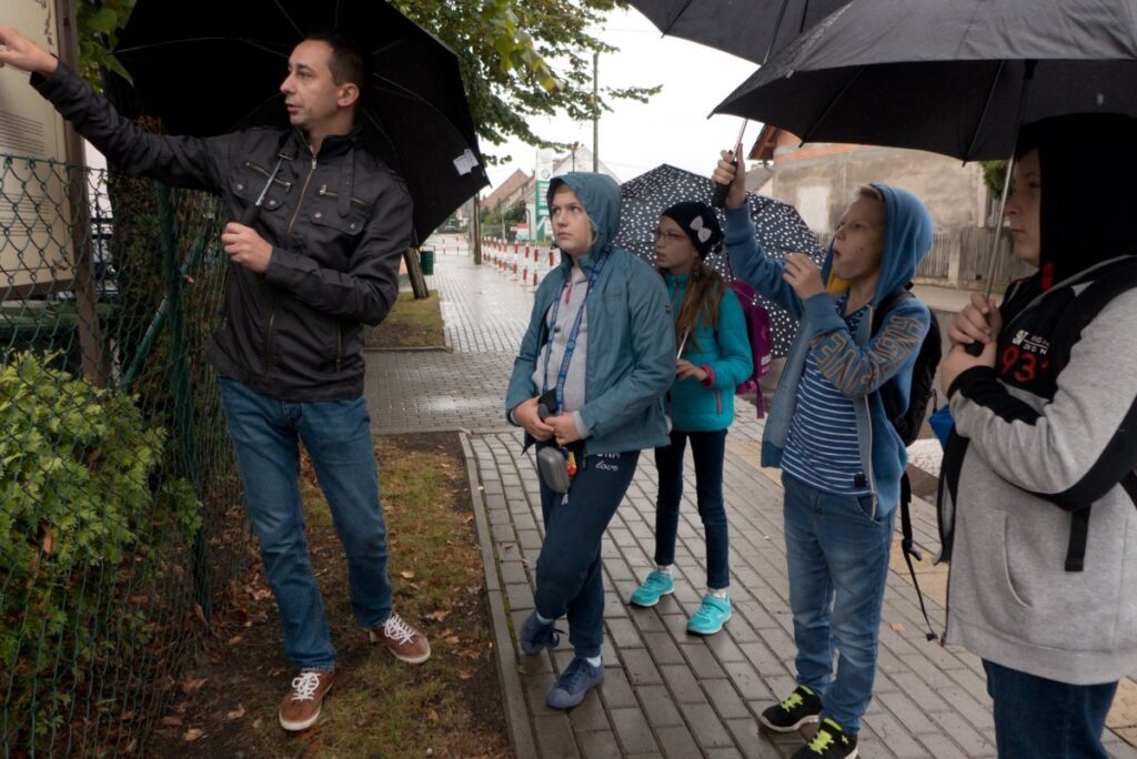 mężczyzna, oprowadza młodzież po okolicy opowiada o