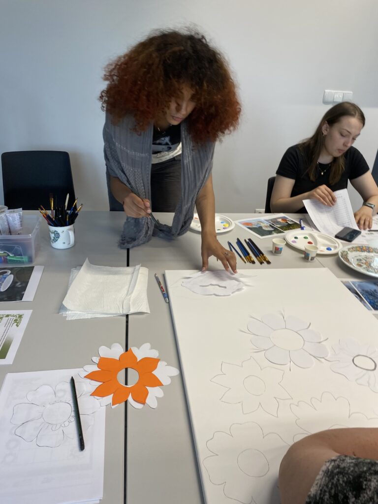 kobieta pochyla się na płótnem malarskim