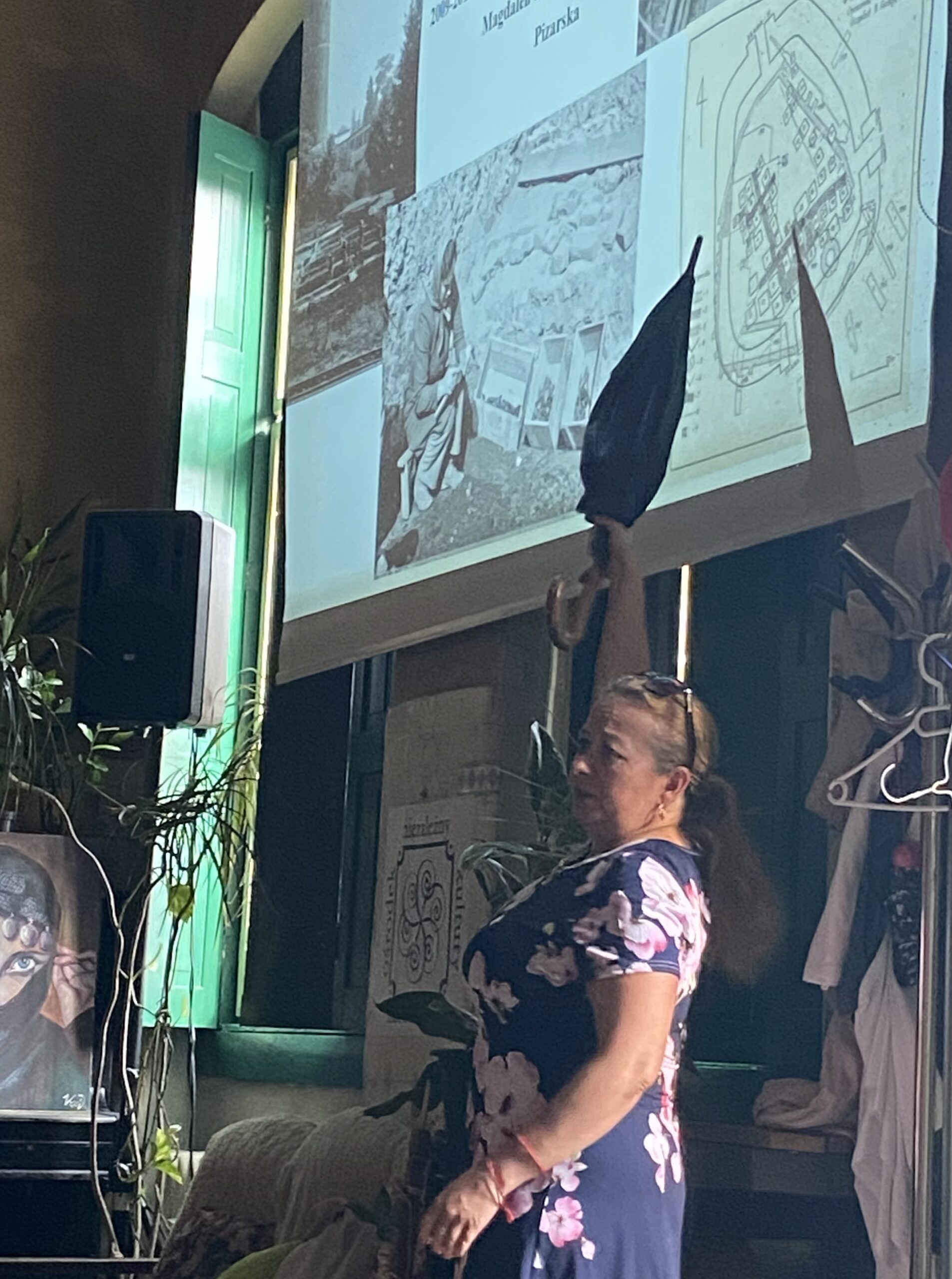 kobieta pokazuje parasolką na obraz wyświetlany na scianie