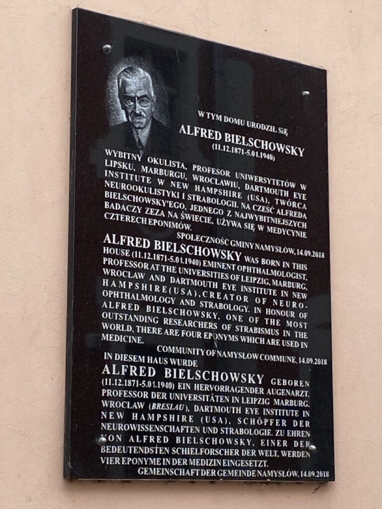 czarna tablica pamiątkowa , umieszczona na elewacji budynku, z wygrawerowaną informacją dot. mieszkańca Namysłowa - dr. Alfreda Bielchowskiego