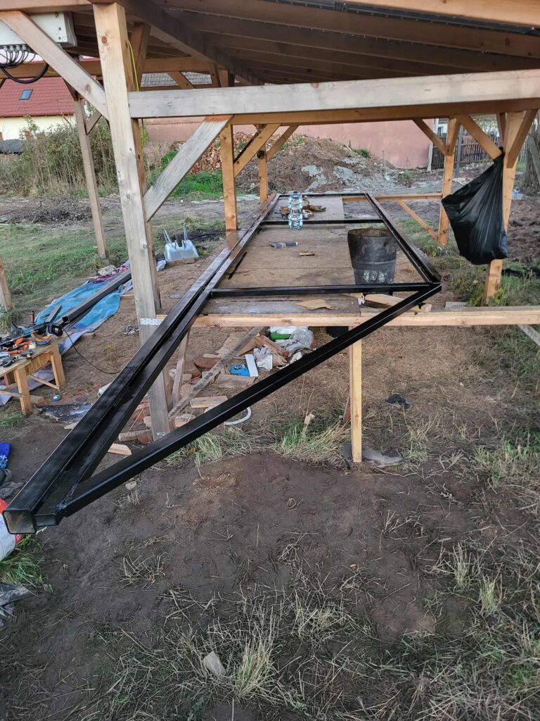 rama bramy podczas budowy leży na dużym stole roboczym w plenerze