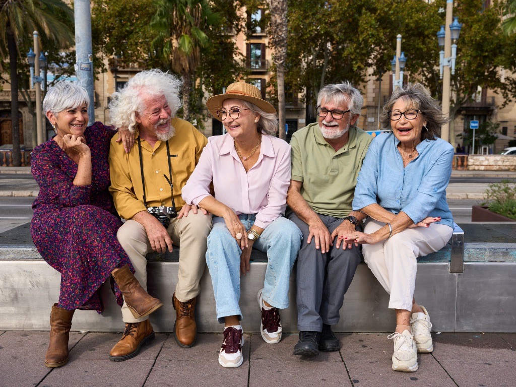 piątka starszych ludzi siedzi na ławce w parku
