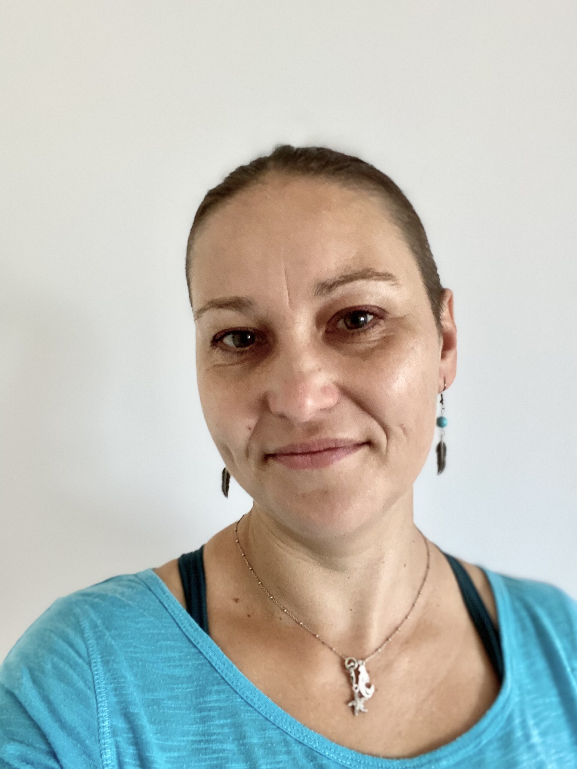 kobieta z gładko związanymi włosami w niebieskiej bluzie