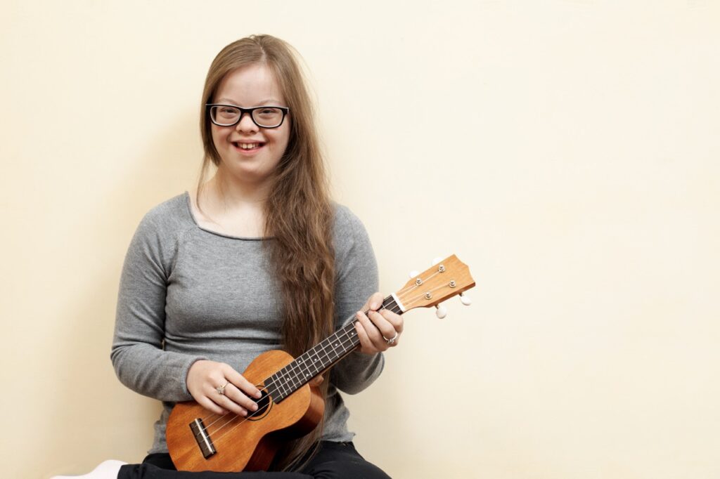 smiley-girl-with-down-syndrome-holding-guitar 